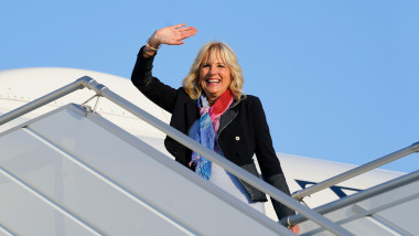 jill biden face cu mana si zambeste in timp ce urca in avion