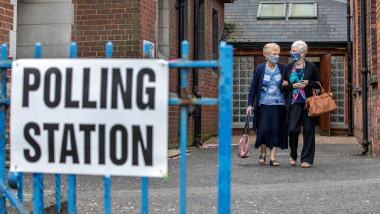 Două femei pleacă de la o secție de vot din Irlanda de Nord.