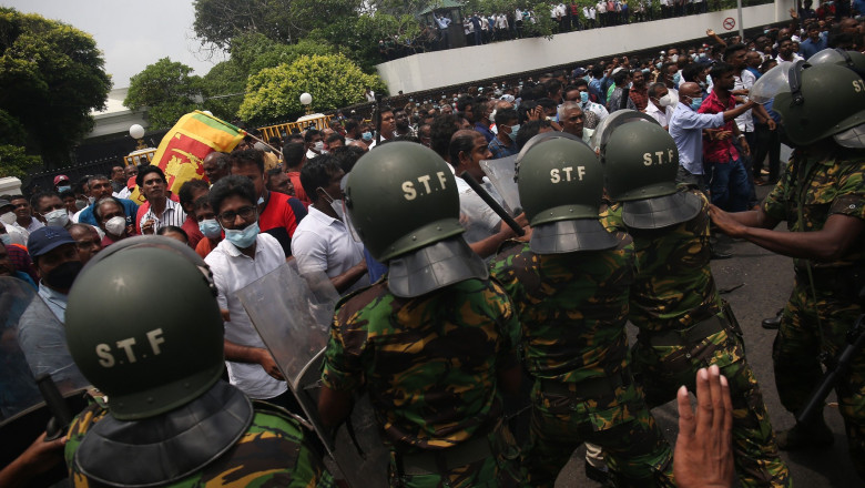 polițiști cu căști verzi în fața unei mulțimi de protestatari în Colombo