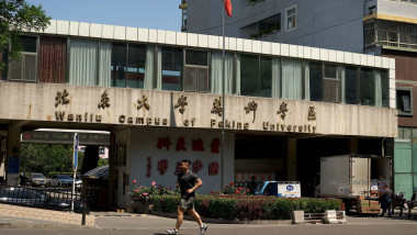 A man jogs in front of the Wanliu campus of Peking University in Beijing on May 16, 2022