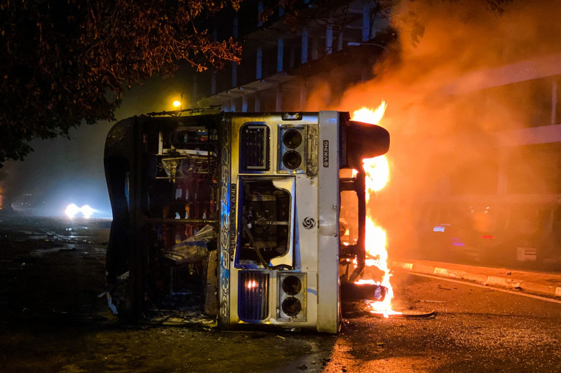 autobuz căzut pe o parte și în flăcări