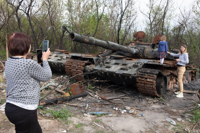 Makariv village, Kyiv region, Ukraine. 7th May, 2022. Two women and a girl are photographed near a destroyed Russian tank. Burned tanks of the Russian invaders near Makariv village, Kyiv region, Ukraine, May 7, 2022. Russia invaded Ukraine on 24 February