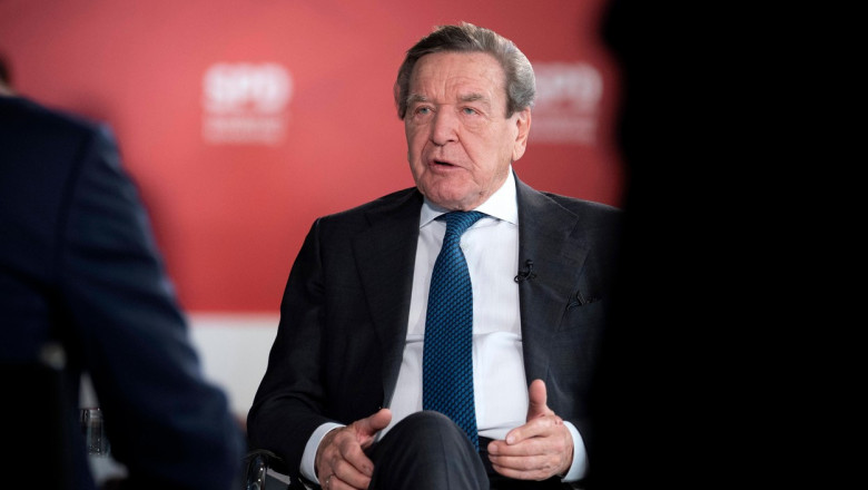 Fostul cancelar german Gerhard Schröder da un interviu pe fundal rosu