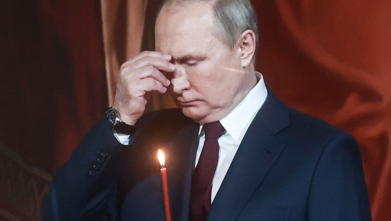 Putin se închină cu o lumânare în mână