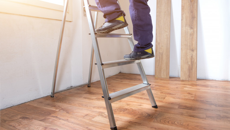 Feet of a carpenter ready for work on a ladder