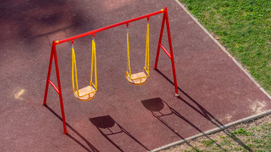 Empty swings on the children playground.