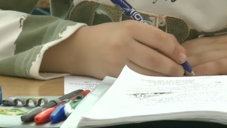 Mâna unui elev care scrie.