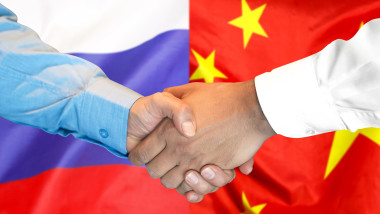 handshake on China and Russia flag background.