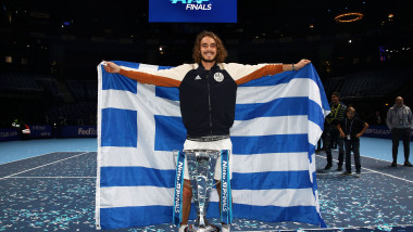 Grecul Stefanos Tsitsipas pozează cu steagul țării și cu trofeul Turneului Campionilor 2019, după finala câștigată în fața austriacului Dominic Thiem