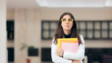 Confused Businesswoman Holding Paperwork in Office Building