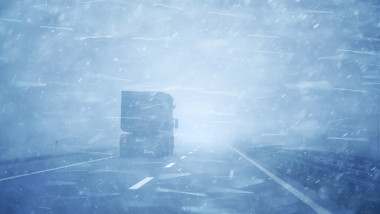 Concept truck vehicle at highway road during a heavy snowfall and rainfall.