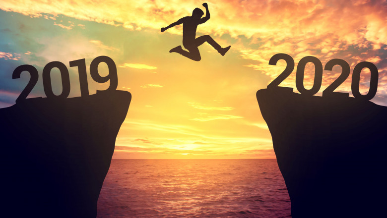 Ajunul Anului Nou - 2019. Barbat care trece din 2019 in 2020 sarind simbolic de pe o stâncă pe alta