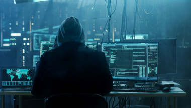 Un hacker stă în fața unui computer