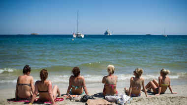 IBIZA, SPAIN - AUGUST 21: A group of tourist sunbathe at Platja d'en Bossa beach on August 21, 2013 in Ibiza, Spain. The small island of Ibiza lies within the Balearics islands, off the coast of Spain. For many years Ibiza has had a reputation as a party destination. Each year thousands of young people gather to enjoy not only the hot weather and the beaches but also the array of clubs with international DJ's playing to vast audiences. Ibiza has also gained a reputation for drugs and concerns are now growing that the taking and trafficking of drugs is spiralling out of control. (Photo by David Ramos/Getty Images)