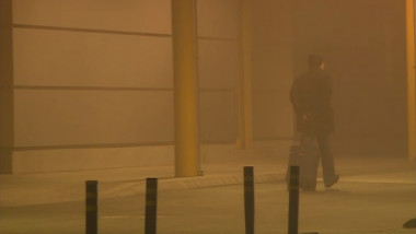 Om care cară un bagaj in afara aeroportului pe timp de ceata