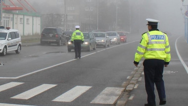 Un politist dirijeaza traficul ingreunat din cauza cetii