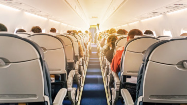 Commercial aircraft cabin with rows of seats down the aisle
