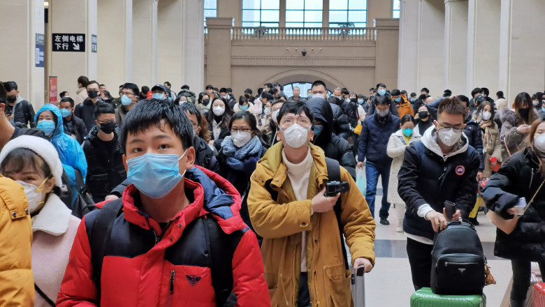 oameni in gara cu masti de protectien pe fata de frica sa nu se contamineze cu noul virus din china