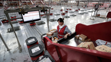 O angajată din China pregateste coletele pentru a fi transportate catre clienti