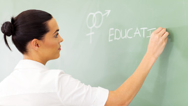 educator writing sex education on chalkboard