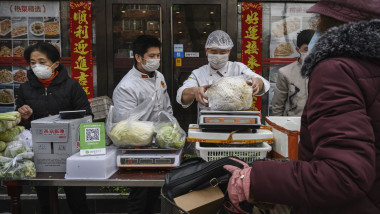 BEIJING, CHINA - JANUARY 26: Chinese vendors wear protective masks as they sell vegetables in the street during the Chinese New Year holiday on January 26, 2020 in Beijing, China. The number of cases of a deadly new coronavirus rose to over 2000 in mainland China Sunday as health officials locked down the city of Wuhan earlier in the week in an effort to contain the spread of the pneumonia-like disease. Medical experts have confirmed the virus can be passed from human to human. In an unprecedented move, Chinese authorities put travel restrictions on the city, which is the epicenter of the virus, and neighboring municipalities affecting tens of millions of people. The number of those who have died from the virus in China climbed to at least 56 on Sunday, and cases have been reported in other countries including the United States, Canada, Australia, France, Thailand, Japan, Taiwan and South Korea. (Photo by Kevin Frayer/Getty Images)
