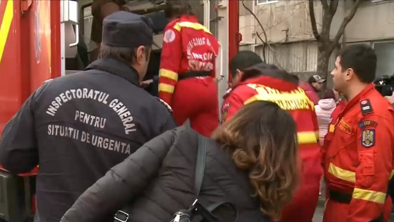 O mamă se uită în ambulanță să vadă dacă acolo se află copilul ei, elev la Școala 133 din București