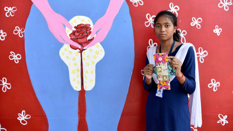 fata din india tinand in mana un tampon de menstruatie reutilizabil