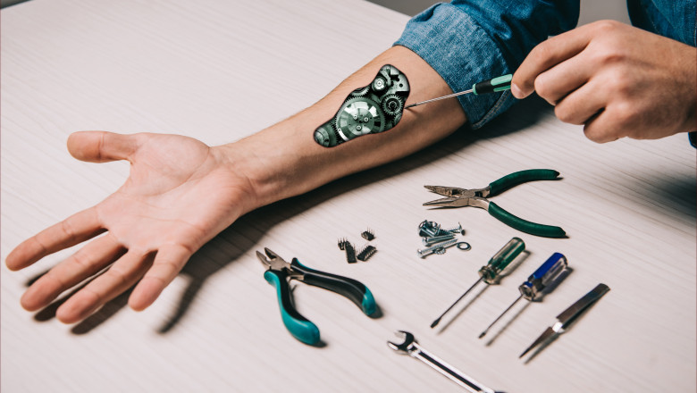 cropped view of man repairing metallic mechanism with screwdriver and pliers