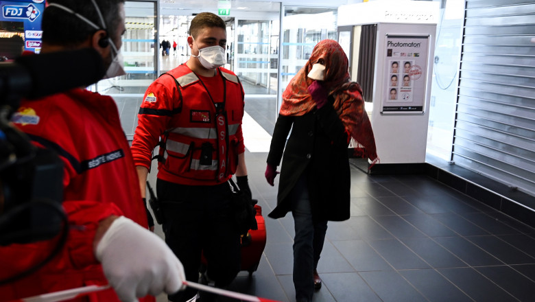 A woman wearing a protective facemask is evacuated from the security zone where a bus comming from Milan is blocked at the train and bus station Lyon Perrache, due to suspected COVID-19 the novel coronavirus on board, in Lyon, on February 24, 2020., Image: 500677182, License: Rights-managed, Restrictions: , Model Release: no, Credit line: JEAN-PHILIPPE KSIAZEK / AFP / Profimedia