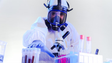 coronavirus epidemic and infectious diseases concept"nmale lab technician doing research in the lab with protective suit and gas mask.