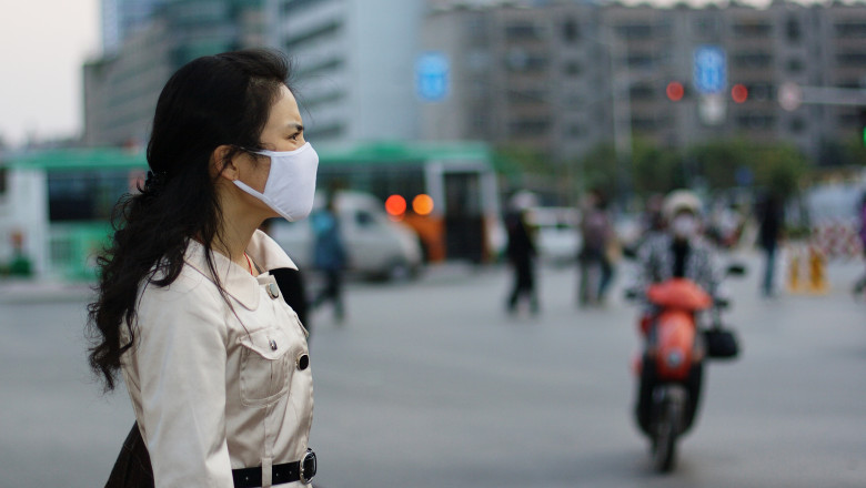 O femeie poarta masca pentru a se proteja impotriva bolilor si a poluarii