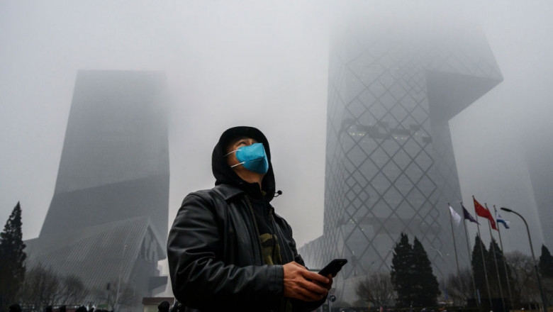 Un barbat din China se protejeaza impotriva poluarii prtand o amsca