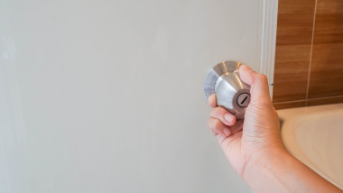 close up women twists doorknob to enter the bathroom