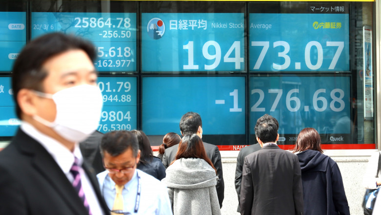 March 9, 2020, Tokyo, Japan - Pedestrians pass before a share prices board in Tokyo on Monday, March 9, 2020. Japan's share prices fell 1,276.68 yen to close at 19,473.07 yen at the morning session of the Tokyo Stock Exchange for the fears of the global economic impact on the coronavirus outbreak. (Photo by Yoshio Tsunoda/AFLO), Image: 504854918, License: Rights-managed, Restrictions: No third party sales, Model Release: no, Credit line: Yoshio Tsunoda / AFLO / Profimedia