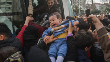 copil plânge în timp ce e urcat într-un autobuz unde sunt îngrămădiți refugiații sirieni la granița Turcia cu Grecia