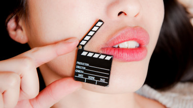 buze senzuale ale unei tinere fete, alături de o clachetă folosită în producţiile cinematografice