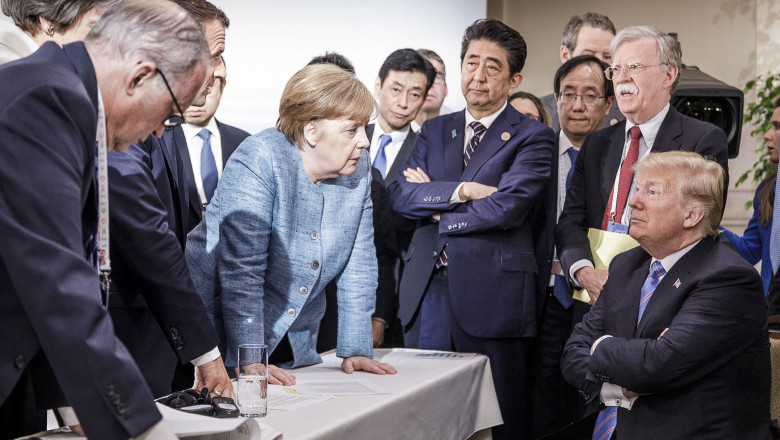 CHARLEVOIX, CANADA - JUNE 9: In this photo provided by the German Government Press Office (BPA), German Chancellor Angela Merkel deliberates with US president Donald Trump on the sidelines of the official agenda on the second day of the G7 summit on June 9, 2018 in Charlevoix, Canada. Also pictured are (L-R) Larry Kudlow, director of the US National Economic Council, Theresa May, UK prime minister, Emmanuel Macron, French president, Angela Merkel, Yasutoshi Nishimura, Japanese deputy chief cabinet secretary, Shinzo Abe, Japan prime minister, Kazuyuki Yamazaki, Japanese senior deputy minister for foreign affairs, John Bolton, US national security adviser, and Donald Trump. Canada are hosting the leaders of the UK, Italy, the US, France, Germany and Japan for the two day summit. (Photo by Jesco Denzel /Bundesregierung via Getty Images)