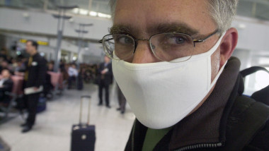 coronavirus barbat cu masca pe aeroport