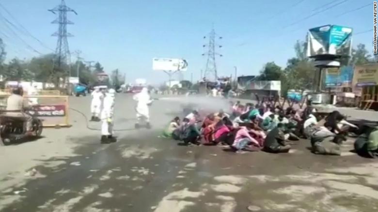 India. Muncitorii intorsi din orasele inchise de carantina, stropiti la gramada cu dezinfectant folosit pentru igienizarea autobuzelor