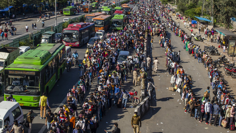GHAZIABAD, INDIA - MARCH 28: Crowds of Indian migrant workers wait to board buses to return to their native villages as a nationwide lockdown continues in an attempt to stop the spread of coronavirus (COVID-19) on March 28, 2020 in Ghaziabad, on the outskirts New Delhi, India. India is under a 21-day lockdown to fight the spread of the virus while security personnel on the roads are enforcing the restrictions in many cases by using force, the workers of country's unorganized sector are bearing the brunt of the curfew-like situation. The lockdown has already disproportionately hurt marginalized communities due to loss of livelihood and lack of food, shelter, health, and other basic needs. The lockdown has left tens of thousands of out-of-work migrant workers stranded, with rail and bus services shut down. According to international labour organisations 90 percent of India's workforce is employed in the informal sector and most do not have access to pensions, sick leave, paid leave or any kind of insurance. The closing of state borders have caused disruption in the supply of essential goods, leading to inflation and fear of shortages. Reports on Thursday said that Prime Minister Narendra Modi's government is preparing a massive bailout for the underprivileged sections of the country and will hand over the aid through direct cash transfers. (Photo by Yawar Nazir/Getty Images)