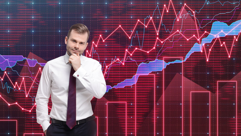 Male trader thinking in front of a colorful forex graph