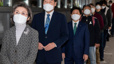 sud-coreeni cu masti pe fata stand la coada la vot