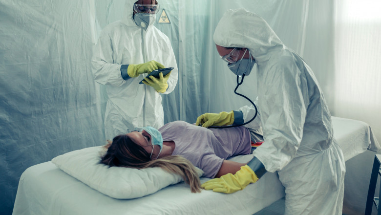 Doctors with bacteriological protection suits attending a patient