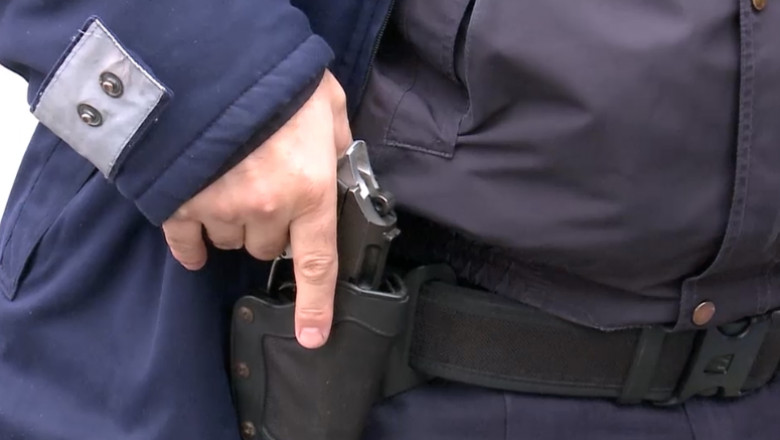 un politist scoate pistolul din teaca