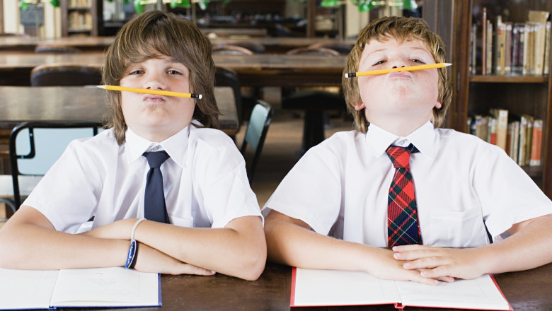 elevi de şcoală ţin creioanele pe buze