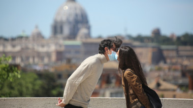 tineri îndrăgostiţi la Roma, se pupă cu măşti pe faţă