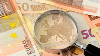 bancnote de 50 de euro cu o lupă peste harta europei