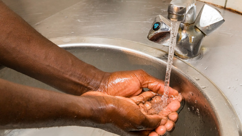 washing their hands in basin to protect against spread of virus