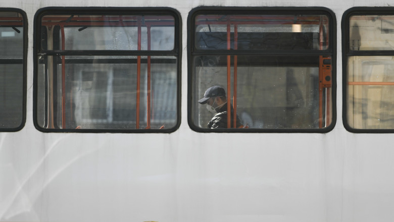 Un barbat poarta masca intr-un tramvai din Bucuresti pentru a se proteja de coronavirus