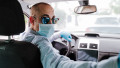 man driving a car wearing protective mask and gloves during pandemic coronacirus covid-19